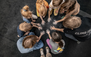 Eine Gruppe von Kindern hat Chalk an den Händen und macht Abdrücke auf die Bouldermatte